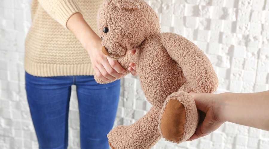 Zwei Hände ziehen an einem braunen Teddybären, was einen typischen Konflikt oder Streit unter Kindern darstellt, der in der Kindersprechstunde gelöst werden kann